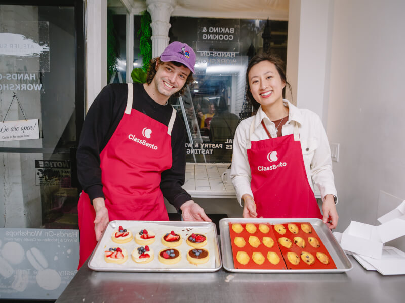 People holding their finished tarts and madeleines